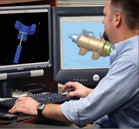 A man is working on a computer with two monitors, designing a 3D mechanical model using CAD software.